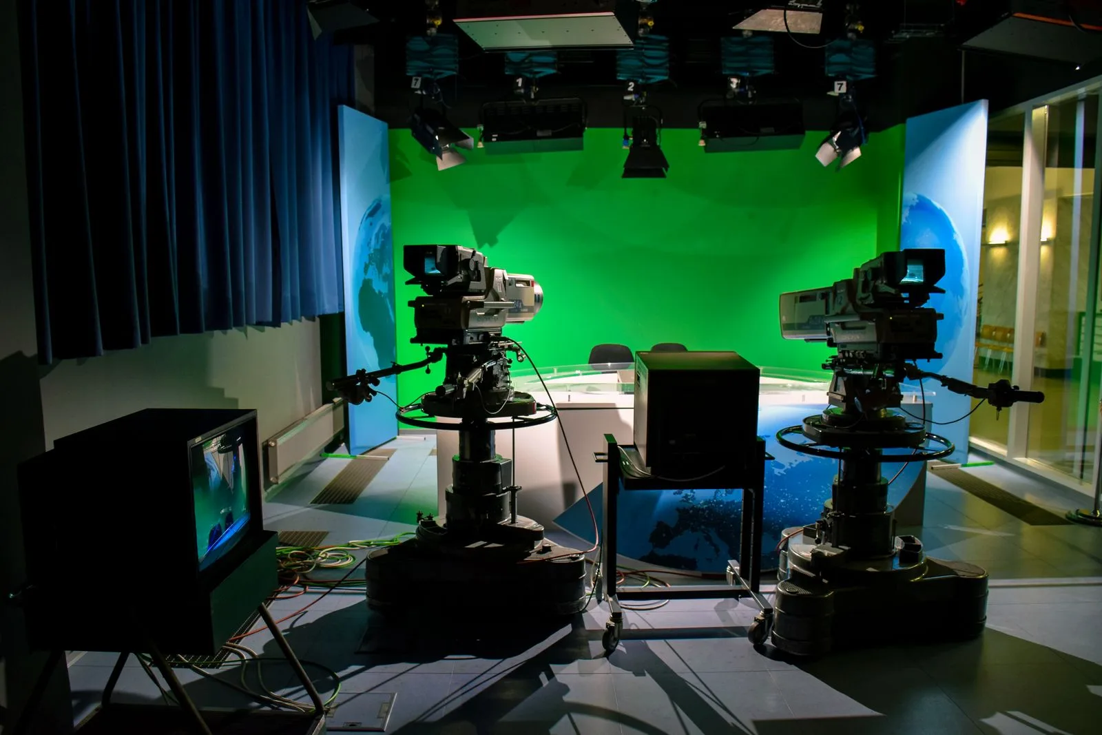 A TV studio with broadcast cameras and a green screen